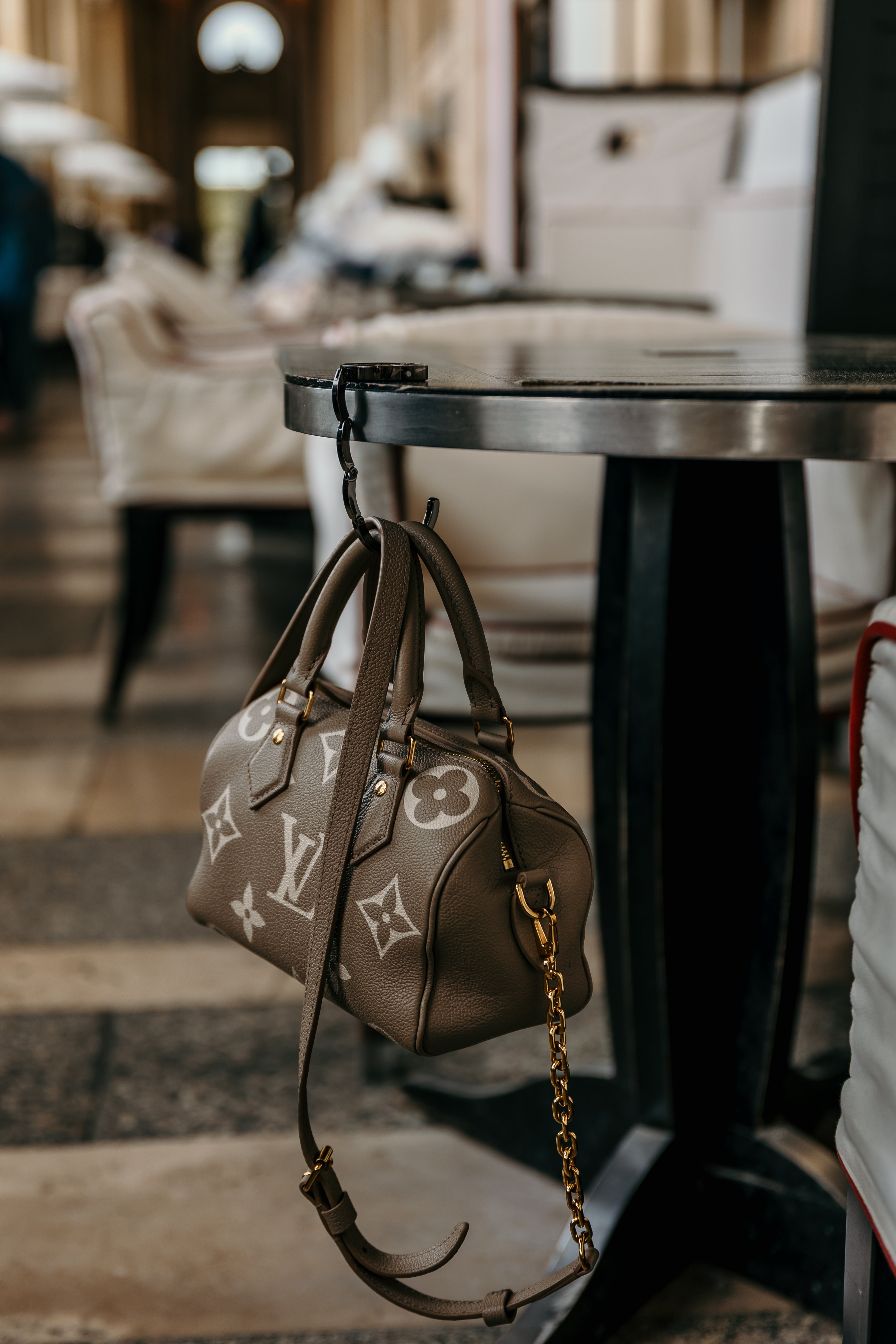 Sundays in Paris Le Petite black purse hook holding a handbag on a restaurant table