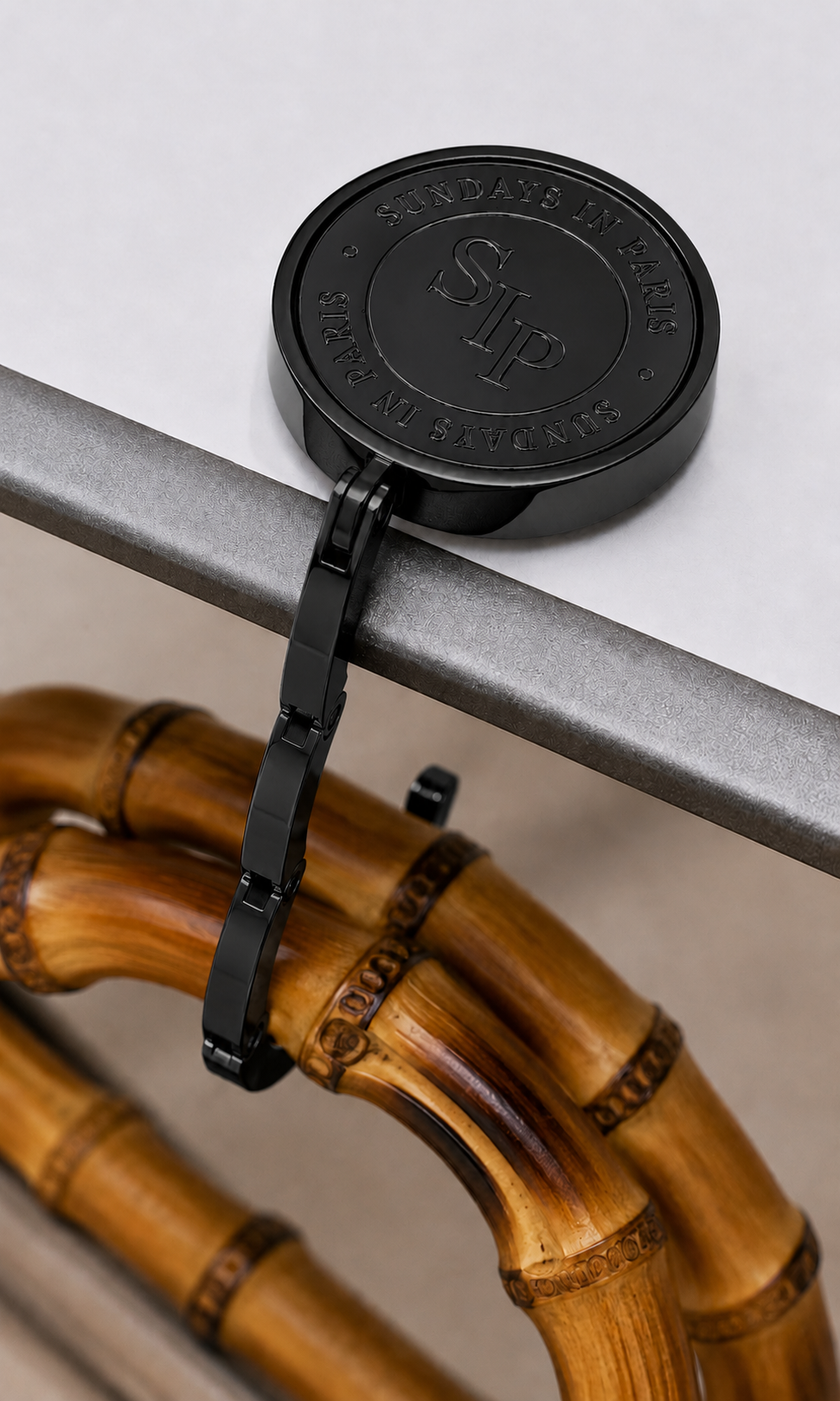 Black Le Petite purse hook by Sundays in Paris, a slim portable table hook